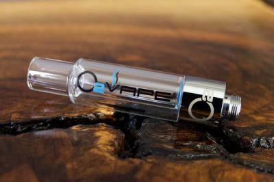 A single uncapped All Glass 510 Vape Cartridge is horizontally laid across a warm wood surface. The O2VAPE logo is visible on the glass body.