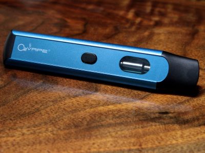 The Option Disposable Vape pen is horizontally displayed across this image, with the base on the left and black mouthpiece on the right. The body is blue with the O2VAPE logo visible at the base, and a black button in the center. Towards the mouthpiece is the liquid chamber.